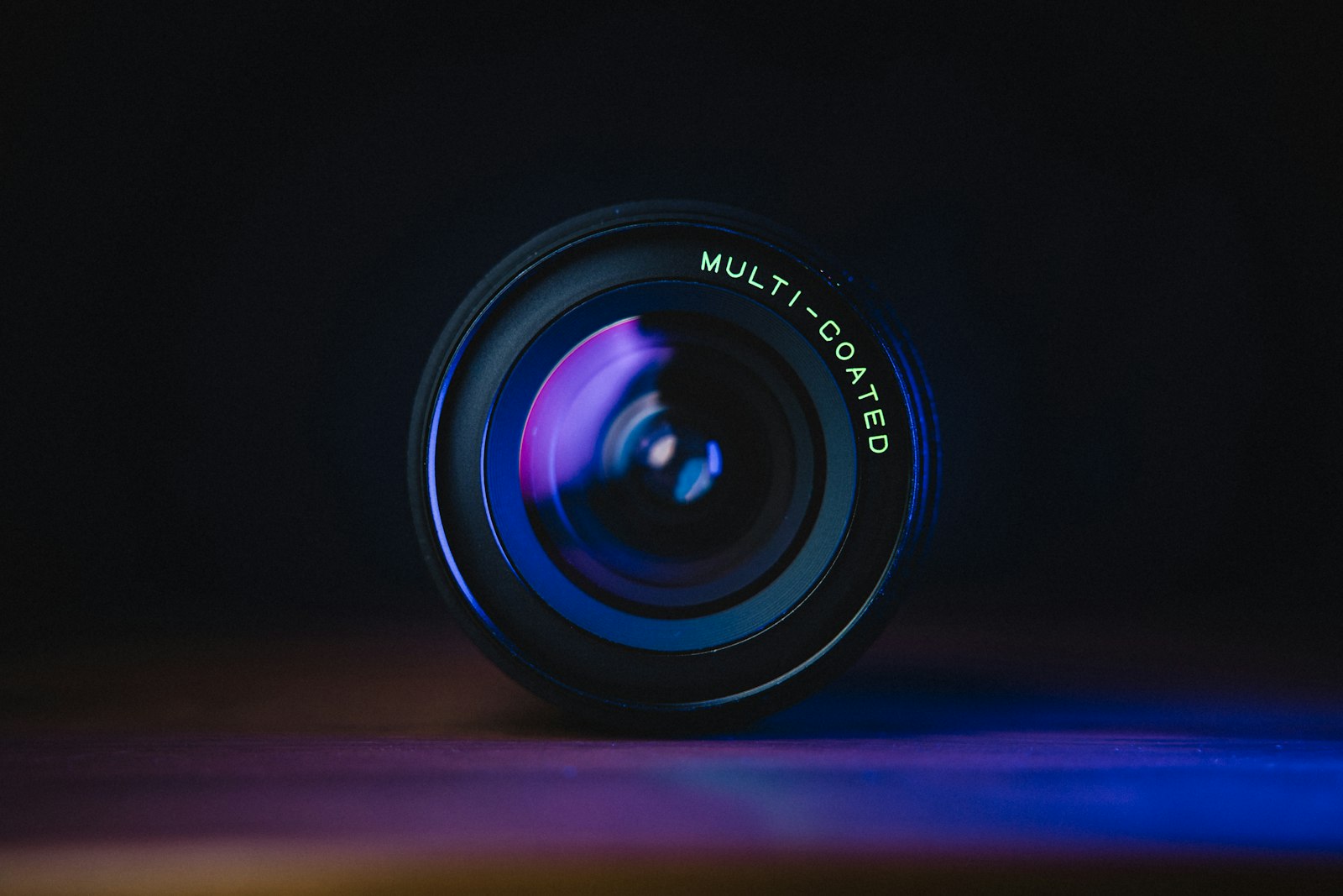 A black camera lens on a blue surface